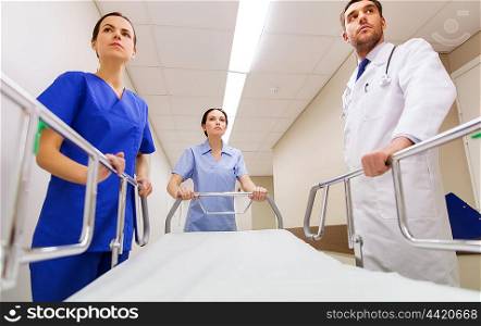 profession, people, healthcare, reanimation and medicine concept - group of medics or doctors carrying hospital gurney to emergency