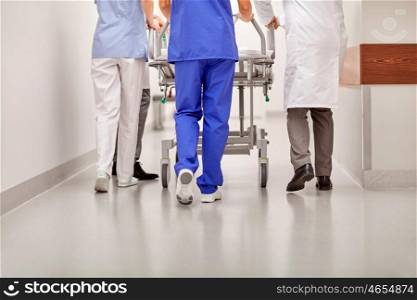 profession, people, healthcare, reanimation and medicine concept - group of medics or doctors carrying hospital gurney to emergency room