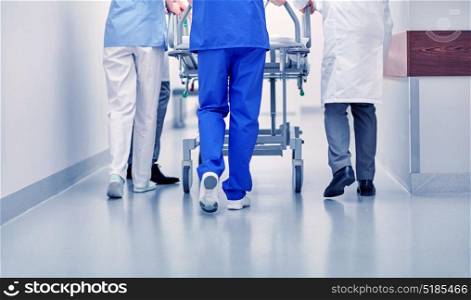 profession, people, healthcare, reanimation and medicine concept - group of medics or doctors carrying hospital gurney to emergency room. medics carrying hospital gurney to emergency room