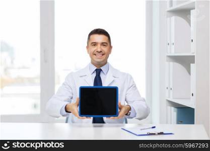 profession, people, technology, advertisement and medicine concept - smiling male doctor in white coat showing tablet pc computer blank screen in medical office