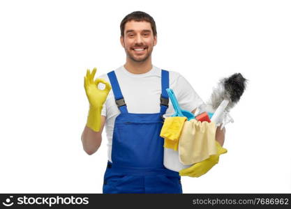 profession, service and people concept - happy smiling male worker or cleaner in overall and gloves with cleaning supplies showing ok hand sign over white background. male cleaner in overall with cleaning supplies