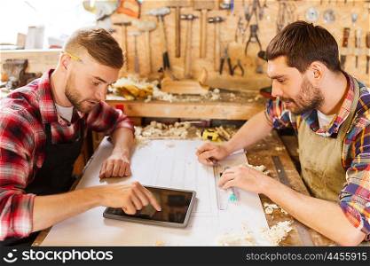 profession, technology and people concept - two workmen with tablet pc computer and blueprint at workshop