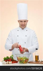 profession, vegetarian, food and people concept - happy male chef cooking and seasoning vegetable salad over beige background