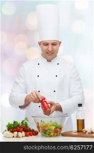 profession, vegetarian, food and people concept - happy male chef cooking and seasoning vegetable salad over blue lights background