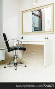 Profession workplace equipment concept. Chair and big mirror in light hairdresser salon. Chair and mirror in hairdresser salon