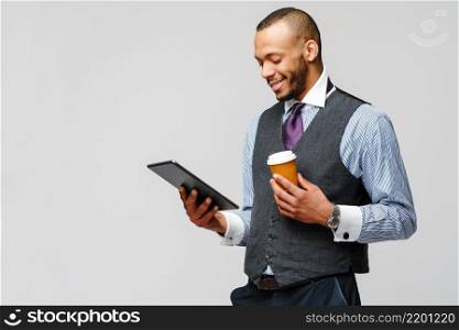 professional african-american business man holding tablet pc and cup of coffee.. professional african-american business man holding tablet pc and cup of coffee