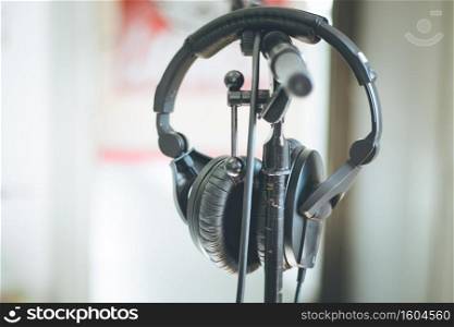 Professional audio headphones with cables on a stand, blurry background