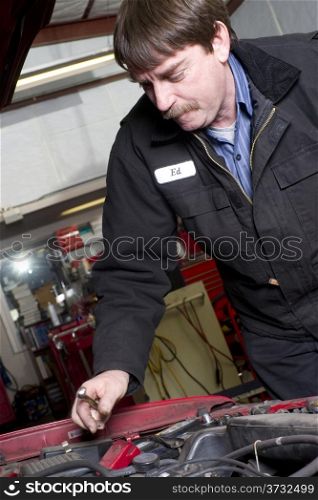 Professional Automotive Technician Works Under the Car Hood in Auto Repair