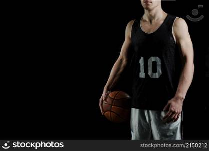 professional basketball player holding ball his arm