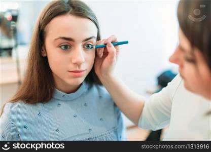 Professional beautician work with woman eyebrows in beauty studio. Cosmetic salon. Professional beautician work with woman eyebrows