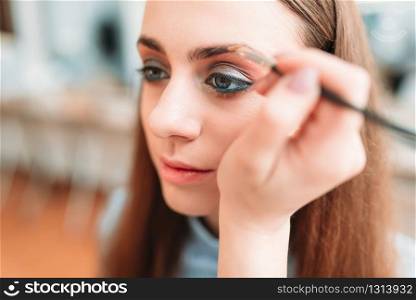 Professional beautician work with woman eyebrows in beauty studio. Cosmetic salon