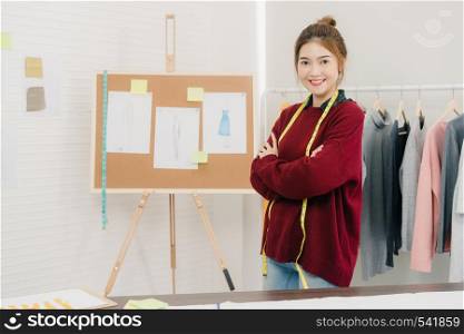 Professional beautiful Asian female fashion designer working measuring dress on a mannequin clothing design at the studio. Lifestyle women working concept.