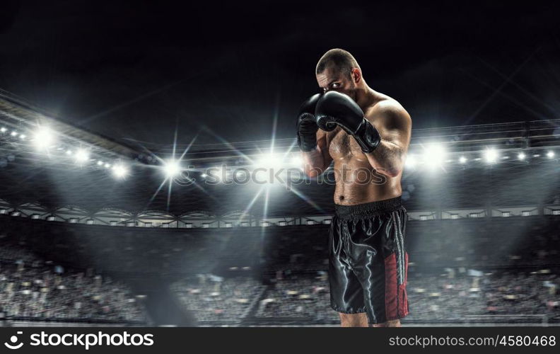 Professional box champion. Professional boxer fighting on arena in spotlights mixed media