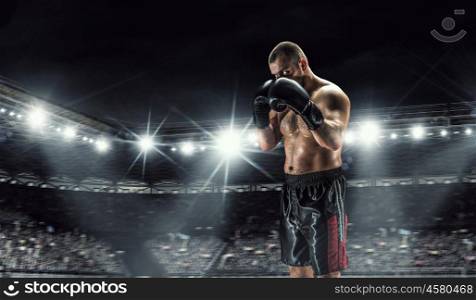Professional box champion. Professional boxer fighting on arena in spotlights mixed media
