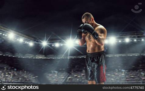 Professional box champion. Professional boxer fighting on arena in spotlights mixed media