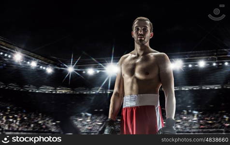 Professional box champion. Professional boxer fighting on arena in spotlights mixed media