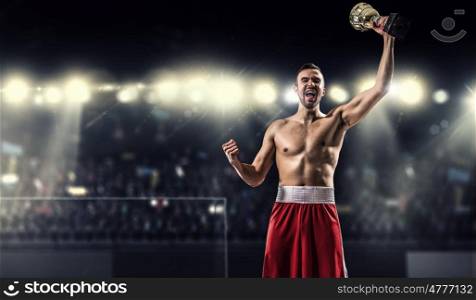 Professional box champion. Professional boxer on arena in spotlights celebrating victory mixed media