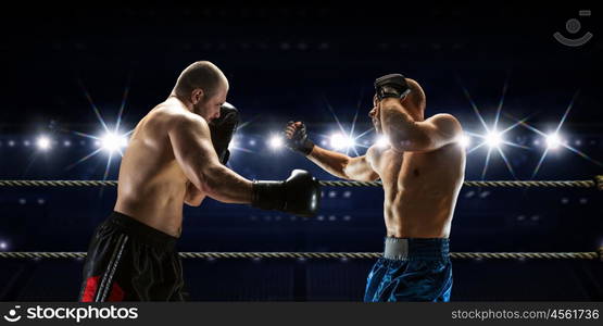 Professional box match. Two professional boxers fighting on arena in spotlights mixed media