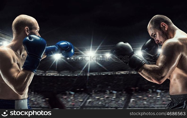 Professional box match. Two professional boxers fighting on arena in spotlights mixed media