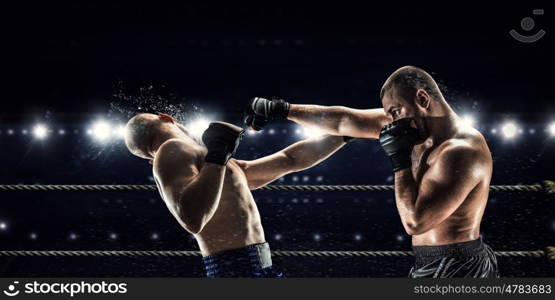 Professional box match. Two professional boxers fighting on arena in spotlights mixed media