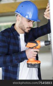 professional builder drilling hole in wall