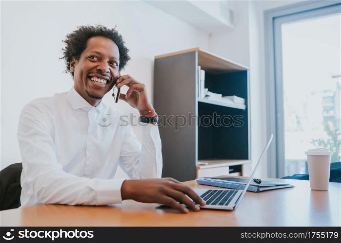 Professional businessman talking on the phone while working at his modern office. Business concept.