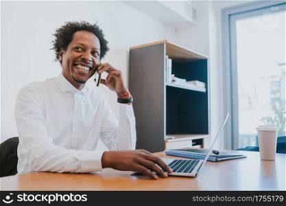 Professional businessman talking on the phone while working at his modern office. Business concept.