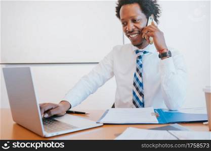 Professional businessman talking on the phone while working at his office. Business concept.