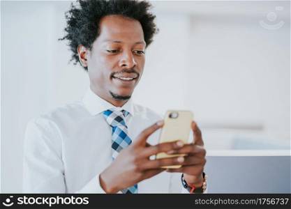 Professional businessman using his mobile phone while working at modern office. Business and technology concept.