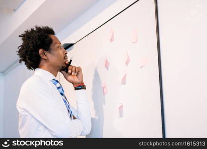 Professional businessman writing on sticky notes and thinking a business plan. Business concept.