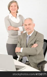 Professional businesspeople behind office table with laptop