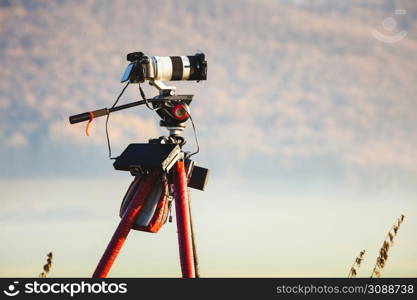 Professional camera on tripod taking picture film video of morning landscape in Slovakia. Camera taking picture film of nature