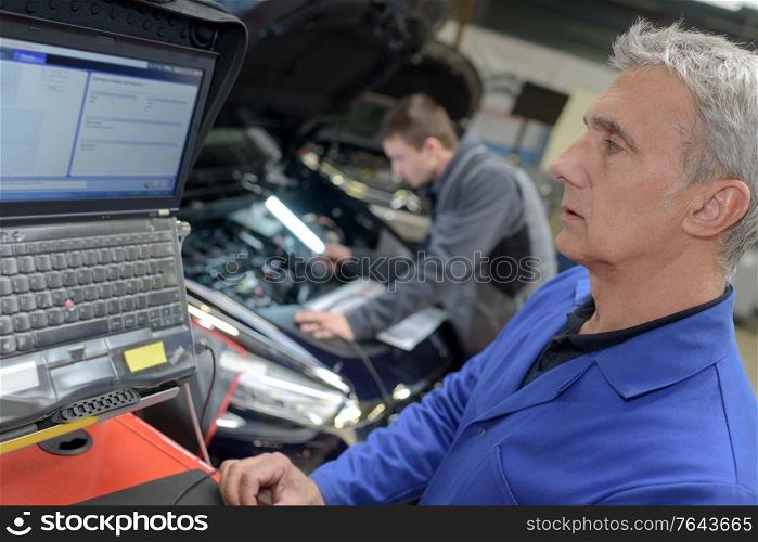 professional car mechanic at his workplace preparing checklist