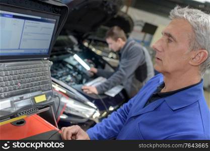 professional car mechanic at his workplace preparing checklist