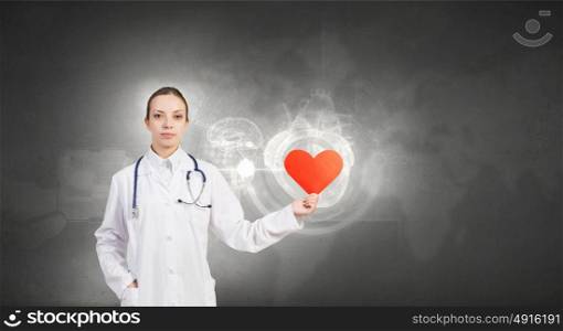Professional care for your heart. Attractive healthcare woman worker with red heart symbol