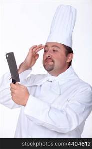 Professional chef checking his image in a knife