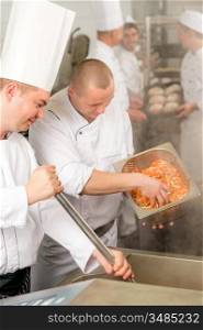Professional chef cook with team prepare food in industrial kitchen