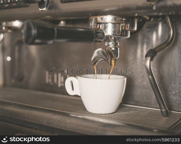 Professional coffee machine with a small white cup ready for coffee being dispensed