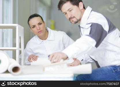 professional couple preparing to wallpaper room