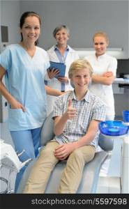 Professional dentist team with teenager boy patient thumbup dental surgery