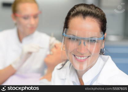 Professional dentist with protective glasses patient woman dental checkup