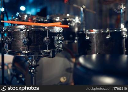 Professional drum kit and sticks closeup, nobody. Rock band concert repetition, live sound performing concept, percussion musical instrument. Professional drum kit and sticks closeup, nobody