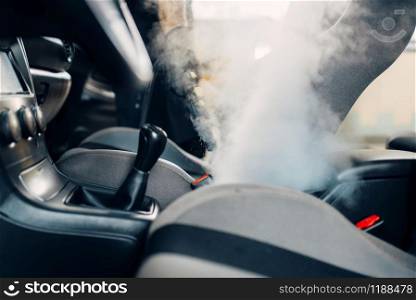 Professional dry cleaning of car interior with steam cleaner. Carwash service, vehicle salon hygiene. Dry cleaning of car interior with steam cleaner