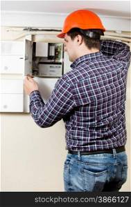 Professional electrician installing components in electrical shield