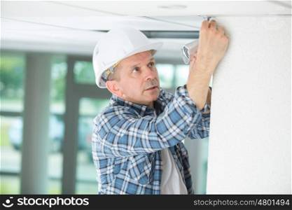 professional electrician replacing the light bulb at home