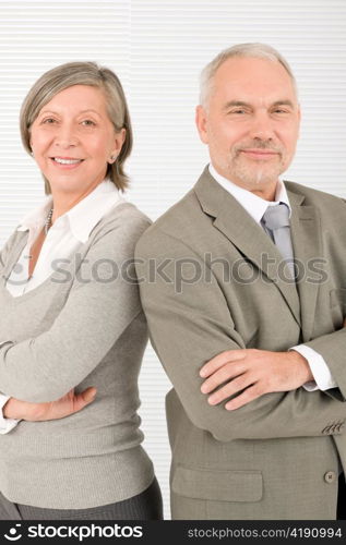 Professional elegant smiling senior businesspeople standing with cross arms