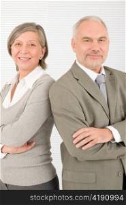 Professional elegant smiling senior businesspeople standing with cross arms