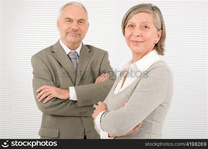 Professional elegant smiling senior businesspeople standing with cross arms