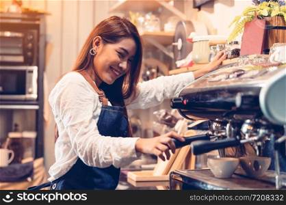 Professional female barista hand making cup of coffee with coffee maker machine in restaurant pub or coffee shop. People and lifestyles. Business food and drink concept. Happy shop owner entrepreneur