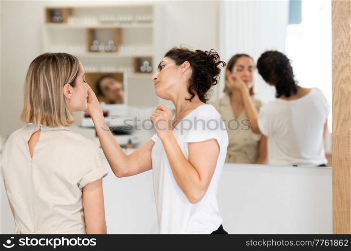 Professional female beautician doing skincare treatment on face of woman in modern beauty center. Cosmetologist doing beauty procedure on face of client